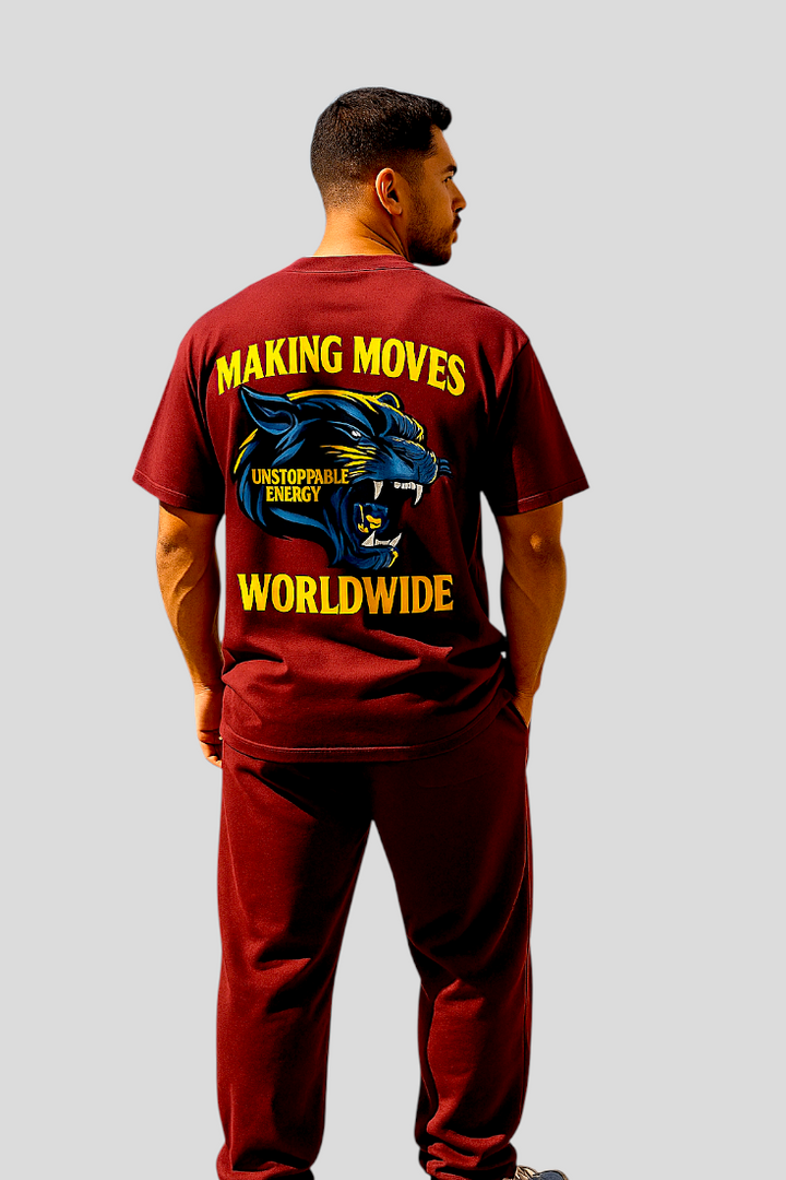 Man wearing maroon UNSTOPPABLE OVERSIZED TEE with 3D panther graphic and "MAKING MOVES WORLDWIDE" text on back