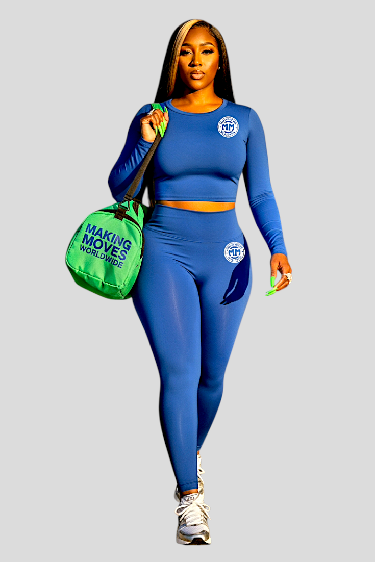 Woman wearing blue Chill & Conquer Lounge Set with matching leggings and long-sleeve crop top carrying green gym bag.
