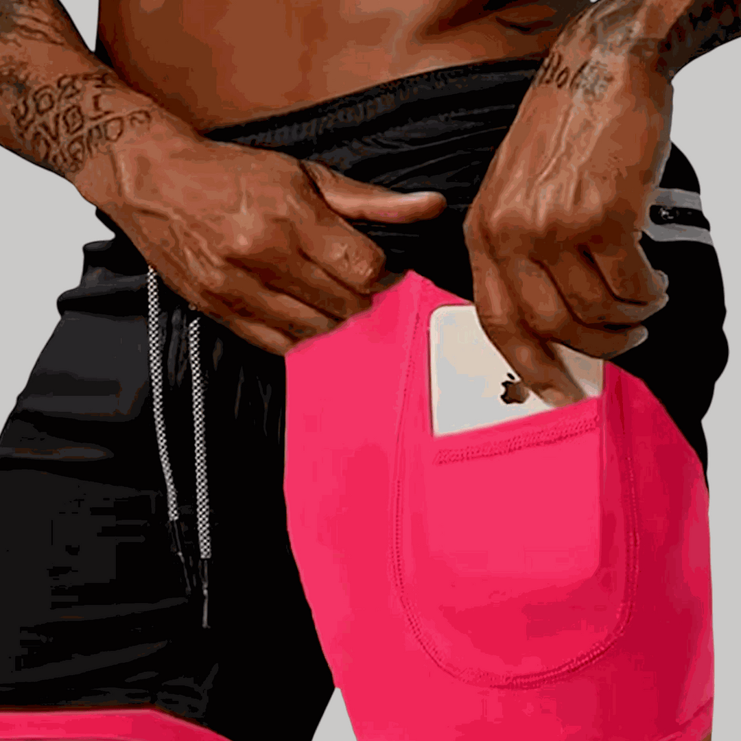 Man wearing black and pink Limitless 5 Shorts with a smartphone in the back pocket, showing drawstring waist and breathable fabric.